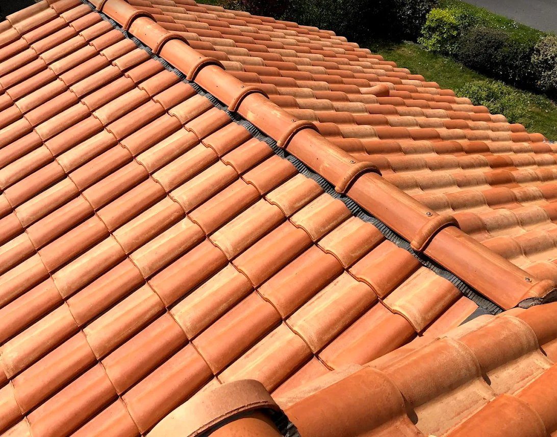 Couverture neuve en tuiles canal avec faîtage à sec ventilé, vue rapprochée d’un toit refait